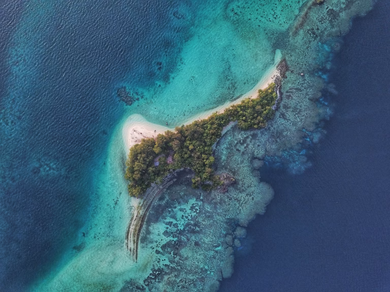 Hidden Island Gems to Visit in 2026 (Before the Crowds Come) 6 Remote small island surrounded by deep blue sea