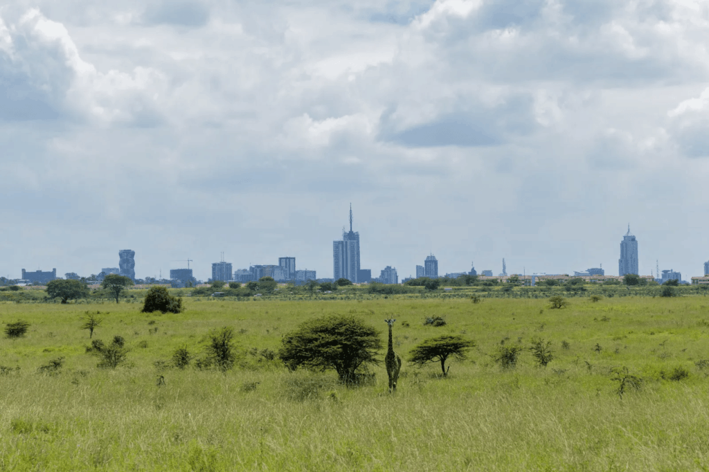 Urban Oases 2026: Explore the World’s Top Green Cities & Parks 7 Nairobi National Park Gate, Kenya, with skyscrapers in the background and savanna in the foreground.