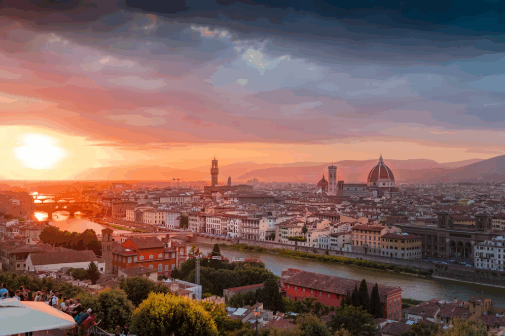 What is the Best Way to Travel Through Italy? 2025 Guide 3 Aerial view of Florence, showcasing its iconic red-tiled roofs, the Arno River winding through the city, and landmarks like the Duomo and Ponte Vecchio set against a backdrop of rolling Tuscan hills.