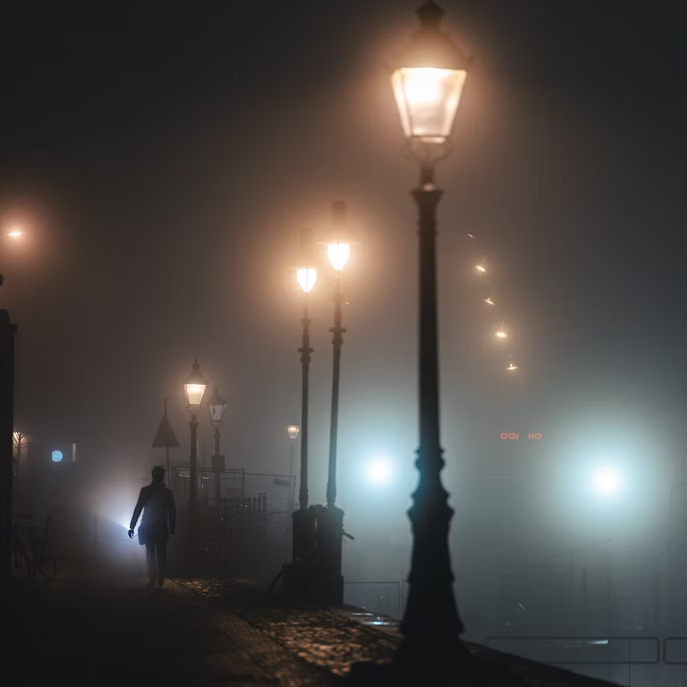 a-person-walking-down-a-street-at-night