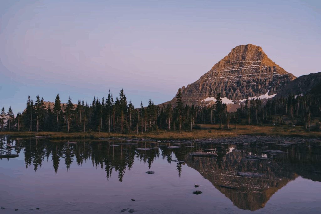 A mountain is reflected in the still water of a lake
