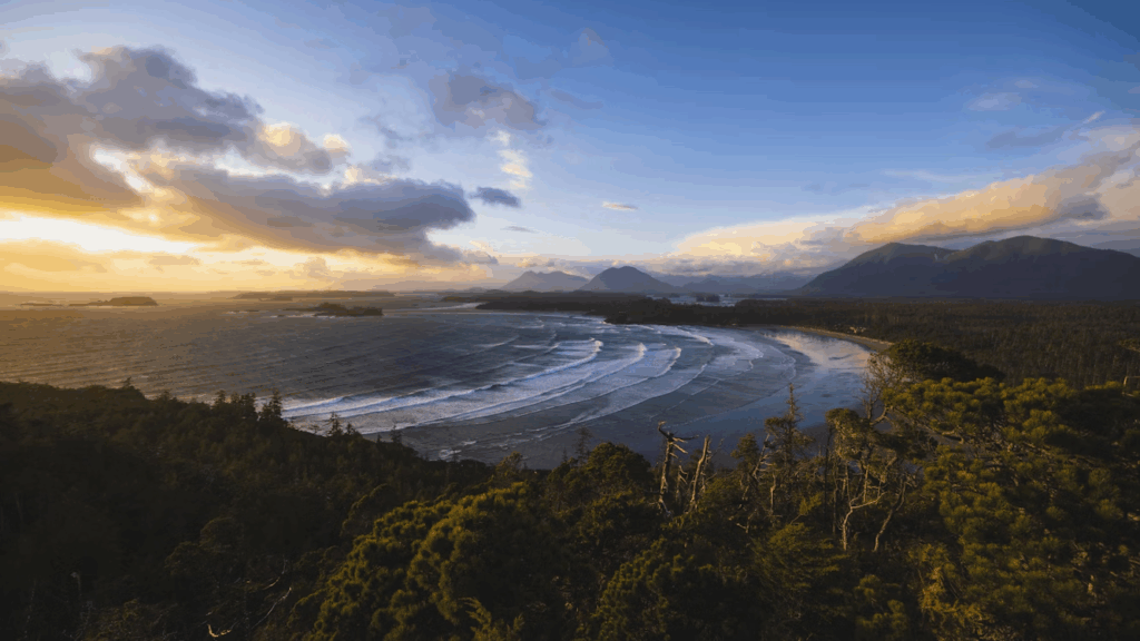 the-sun-is-setting-over-the-ocean-and-mountains