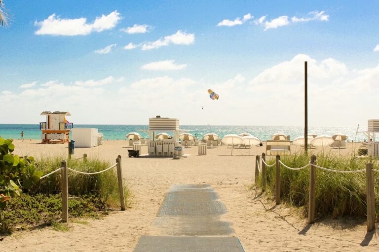 gray pathway leading to parasol, lifeguard house, and sea a daytime in South Beach, Miami Beach.