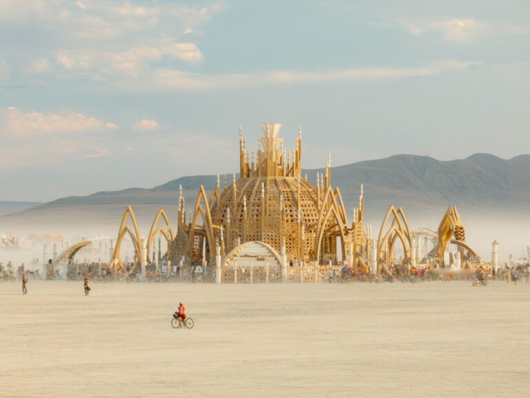A group of festival-goers walking across a sandy desert at Burning Man